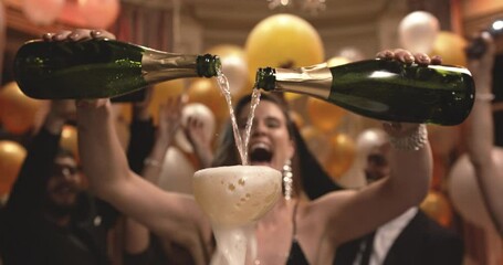 Young woman filling champagne into a tower of glasses with friends dancing around at gala night party. Group of multiethnic people having a great time at new years party.
 - Powered by Adobe