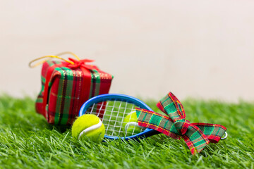 Tennis ball with gift are on green grass
