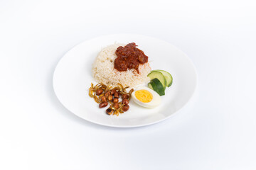 Nasi Lemak-Malaysian cuisine. A fragrant rice dish cooked in coconut milk and pandan leaf commonly found in Malaysia. Served with sambal, anchovies, peanut, and cucumber. center of the frame