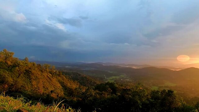 mountains range misty shadow with dramatic colorful sunset sky at dusk from flat angle
