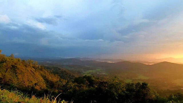 mountains range misty shadow with dramatic colorful sunset sky at dusk from flat angle