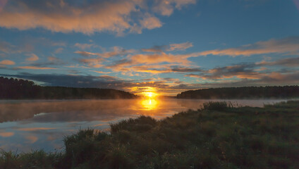 Summer dawn on a pond with fog