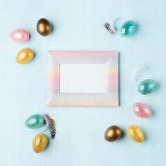 Fototapeta na wymiar Easter greeting card with colorful easter eggs on blue background. Top view, flat lay with space for your text.