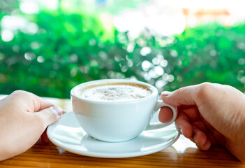 White coffee hot cup morning breakfast on wooden table with nature background. Hot cappuccino coffee. Copy space.