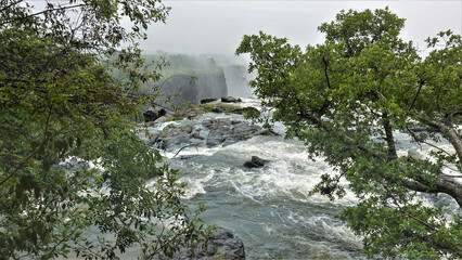 Zambezi river before falling into the abyss. Rough water foams in the rocky river bed. The edge of...