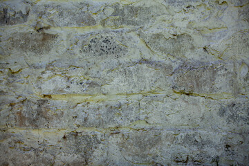 Gray brick wall with yellow putty.