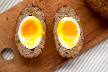 Homemade Scotch Eggs on a rustic wooden board, top view. Flat lay, overhead, from above. Close-up.