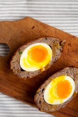 Homemade Scotch Eggs on a rustic wooden board, overhead view. Flat lay, top view, from above. Close-up.