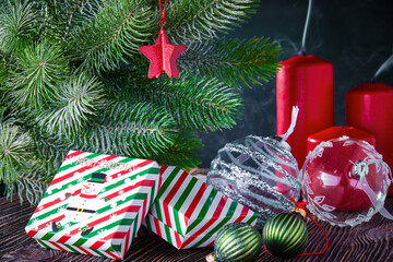 Christmas background with gifts, extinguished candles and decorated with a spruce branch.