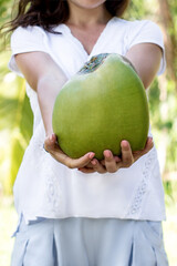 girl holding a green coconut