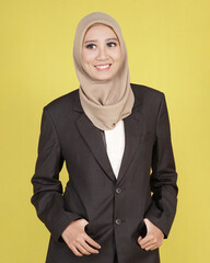 Hijab female models pose like famous models. The woman is wearing a set of office suits. pose while standing and sitting on a tall wooden chair.