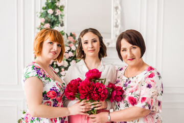 portrait of mother, grandmother and daughter with flowers