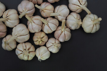 Bulbs of garlic (Allium sativum) on black background. Flat lay concept
