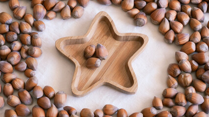 Fototapeta na wymiar Raw hazelnuts on bamboo star shape plate. High quality photo