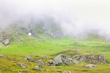 Majestic green and rocky mountain in fog 