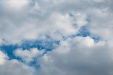 Blue cloudy sky background. Fluffy cumulus environment in high atmosphere. Dramatic stormy cloudscape, thunderstorm heaven. Beautiful ambience with cumulonimbus cloud