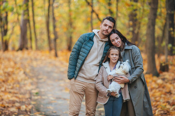Naklejka na ściany i meble Portrait of happy family of three in autumn day