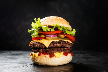 Fresh tasty double hamburger on black background.