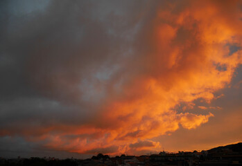 Colorful cloudy sunset sky over the town