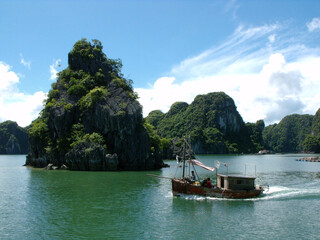 Ha Long Bay, Vietnam, June 23, 2016: Fishing boat crossing Ha Long Bay. Vietnam