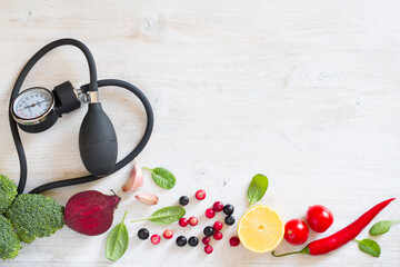 Heart-shaped blood pressure monitor and vegetables with fruits to prevent hypertension, healthy...
