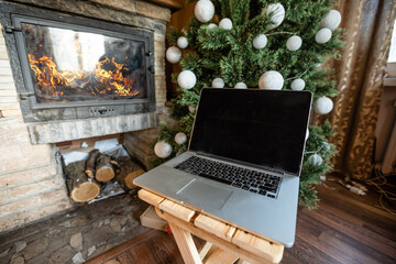 laptop and christmas tree in an old wooden house