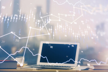 Stock market chart hologram drawn on personal computer background. Double exposure. Concept of investment.