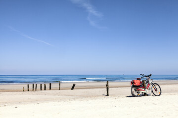 Zwei Fahrräder lehnen an den Buhnen am Strand