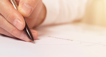 Contract signing concept. Businessman hand with golden and black pen over signature space close up