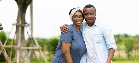 African American couple in love smiling and looking at camera outdoors at park