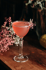 Elegant red cocktail with flowers on the background.