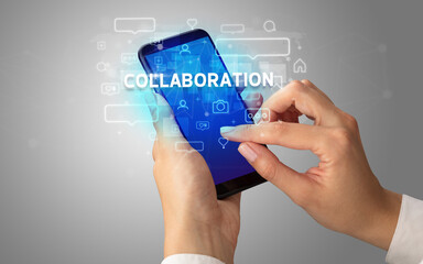 Female hand typing on smartphone with COLLABORATION inscription, social media concept