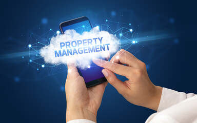 Female hand touching smartphone with PROPERTY MANAGEMENT inscription, cloud business concept
