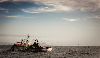Barco de pesca faenando con redes