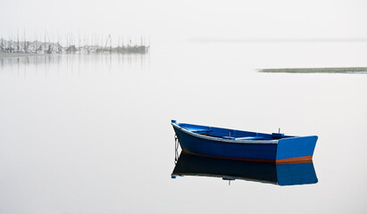 Barca azul en el agua con niebla 