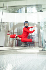 levitation of sports people in a wind tunnel. jumping without a parachute in a wind tunnel indoors. Man in a red suit, portrait of a skydiver