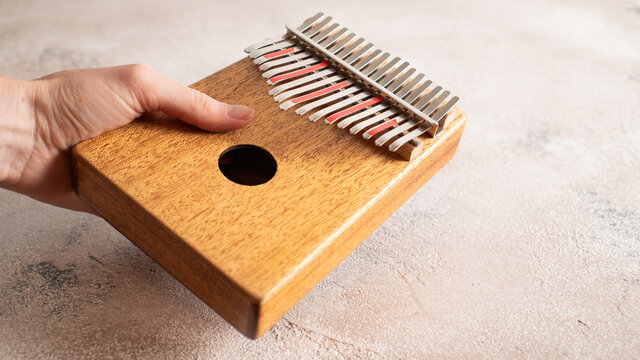 Han holding Kalimba, mbira, finger harp, gourd piano,, kilembe, likimba, marimbula, sansa, sansu, sanza, thumb piano