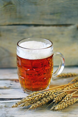 Selective focus. Fresh live wheat beer and ears of wheat. Brewery concept.
