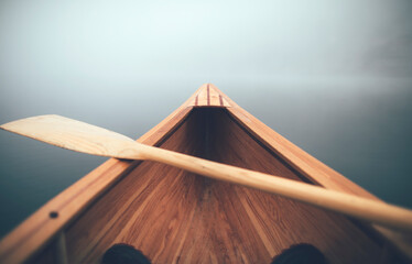 Winter canoeing. Canoe bow and paddle on the foggy lake