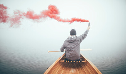 Man in canoe using smoke bomb for signal his position