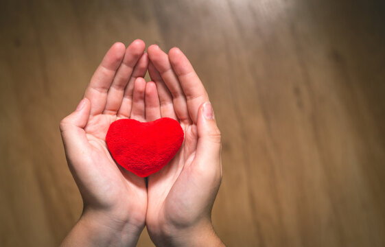 Red heart in hands symbolizing healthcare and self-love. health, love, and support concept. Image for medicine articles