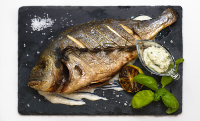 Baked fish on the black stone surface