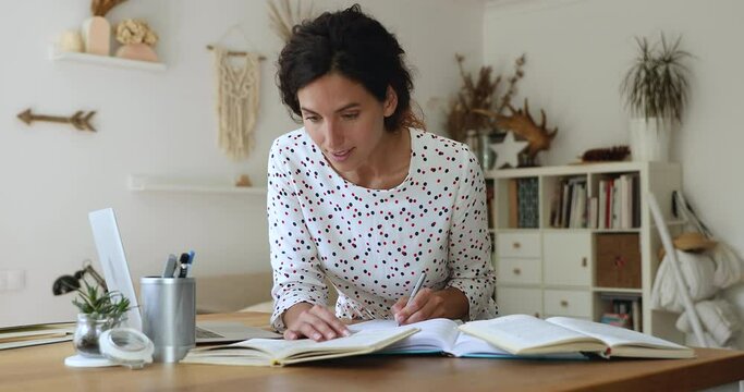 Young woman learner lean at desk full of textbook professional educational literature, getting second higher education, prepare dissertation studying at home, advanced training, self-education concept