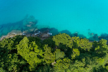 Naklejka na ściany i meble Drone aerial view shot of Tropical sea with green trees beautiful seashore island in Phuket Thailand.