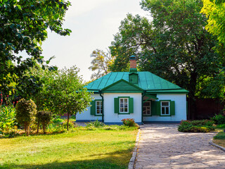 small one-story white house with green roof - rustic architecture