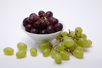White bowl with grapes on a white background.