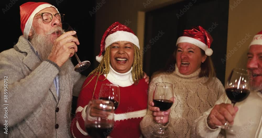 Wall mural Happy senior people celebrating Christmas time drinking wine together  - Wall murals