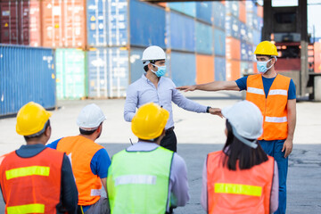 foreman is teaching and training workers how to wear face masks and take care of themselves while...