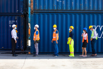 Temperature measurement with employee temperature meter before entering work at container yard. worker wearing protection face mask during coronavirus and flu outbreak.