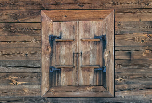 Texture of an old weathered wooden wall and closed window